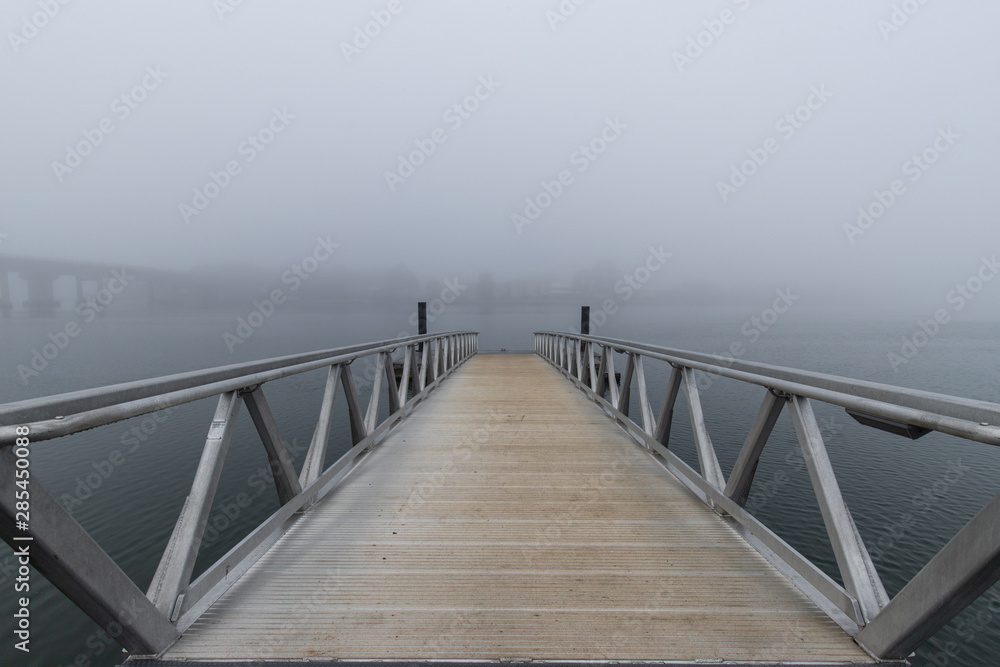 A pier view into the fog.