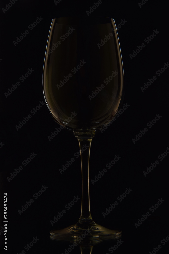 The photo shows a glass wine glass on a black background The photo shows a glass wine glass on a black background
