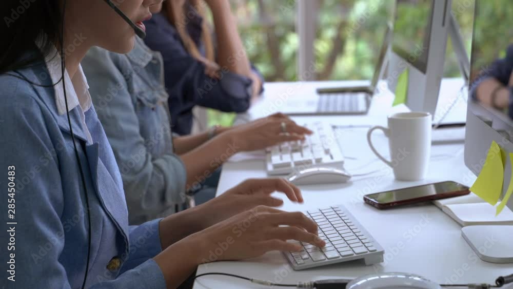 The beautiful call center staff are typing keyboards and talking in a friendly way, providing smiling services, caring for the service. The beautiful call center staff are typing keyboards and talking in a friendly way, providing smiling services, caring for the service.