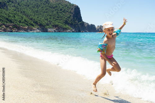 Happy child playing in the sea. Kid having fun at the beach.