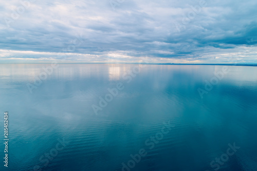 Minimalist aerial seascape. Overcast sky over calm and smooth water surface