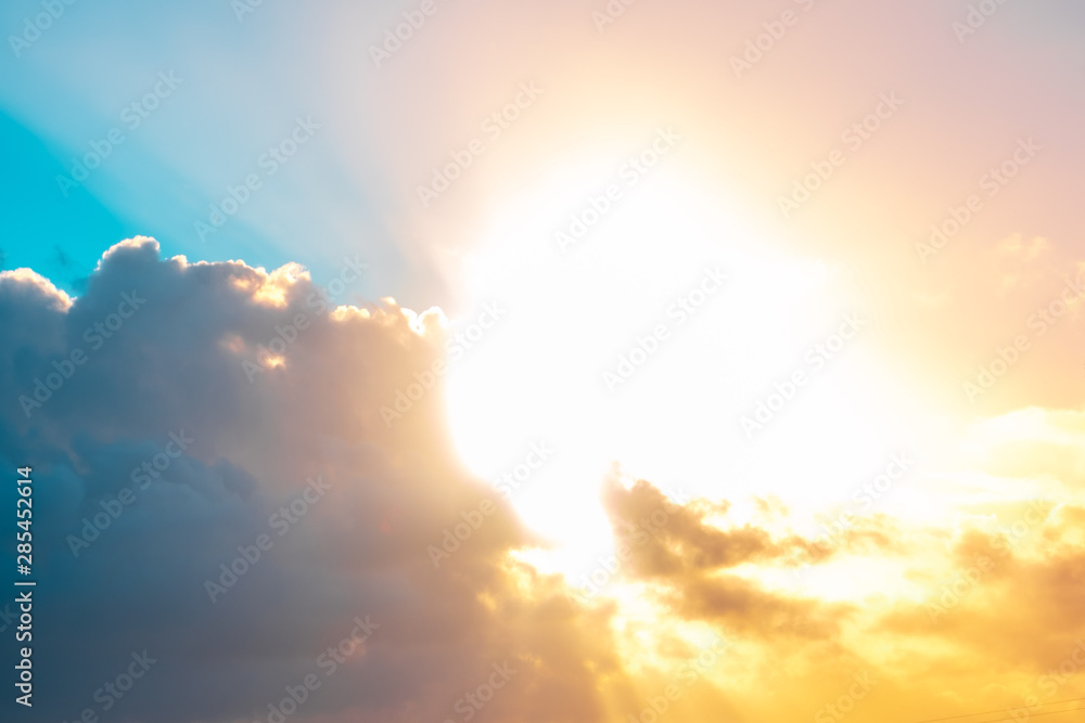 Bright sunshine through storm clouds at sunset - colorful background overlay