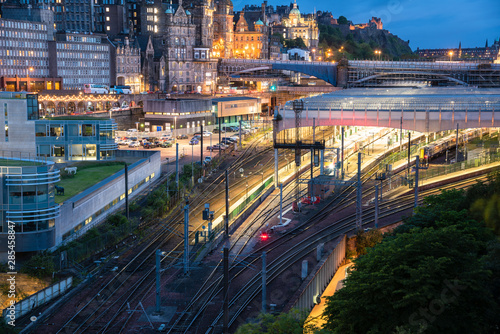 View from above of railroad tracks and a train station in a city centre at Dusk. Edinburgh, Scotland.