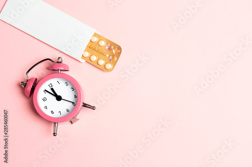 Cuadro en lienzo Female oral contraceptive pills blister with alarm clock on pink background