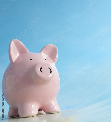 Piggy bank on blank blue background