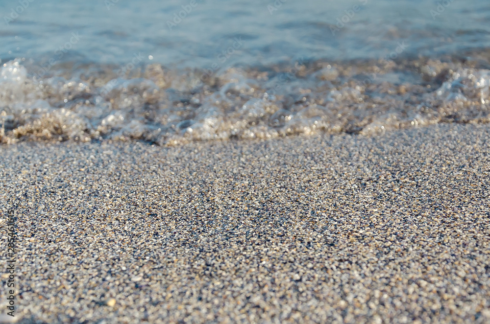 Closeup of sandy beach with soft incoming waves. Selective focus Closeup of sandy beach with soft incoming waves. Selective focus