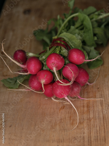 Lying bunch of red ripe radishes on a wooden Board. Rustic style. Save space.