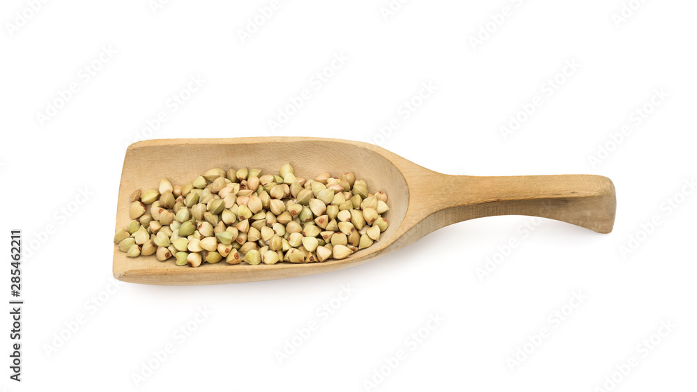 Some green buckwheat on a wooden spoon or scoop seen obliquely from above and isolated on white background Some green buckwheat on a wooden spoon or scoop seen obliquely from above and isolated on white background