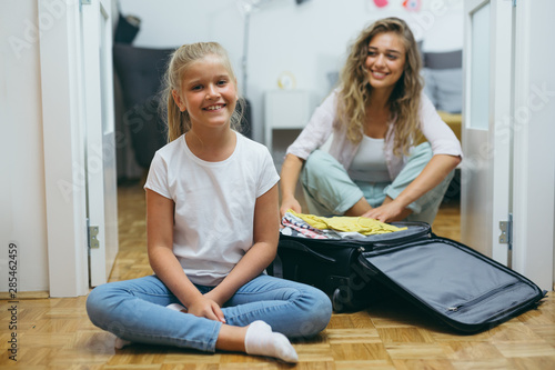 mother and daughter packing bags for summer vacation