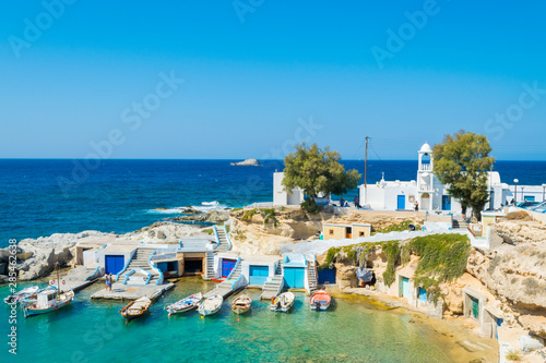 A small harbor with fishing boats and crystal clear turquoise waters in Mandrakia village in Milos island, Greece