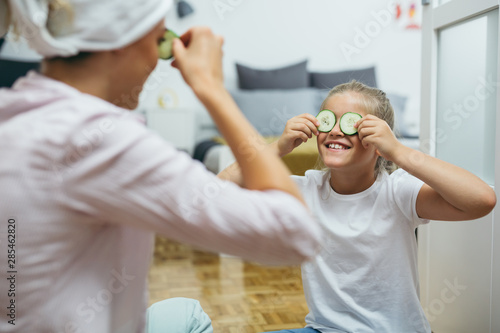 Fotografie, Obraz mother and daughter applying cosmetic face mask at home