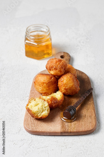Obraz na płótnie Cottage cheese balls doughnuts is jam-packed with jelly filling on wooden cut board and glass jar honey w salonie