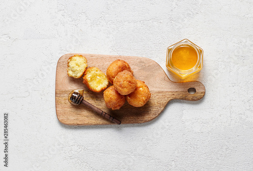 Obraz na płótnie Cottage cheese balls doughnuts is jam-packed with jelly filling on wooden cut board and glass jar honey w salonie