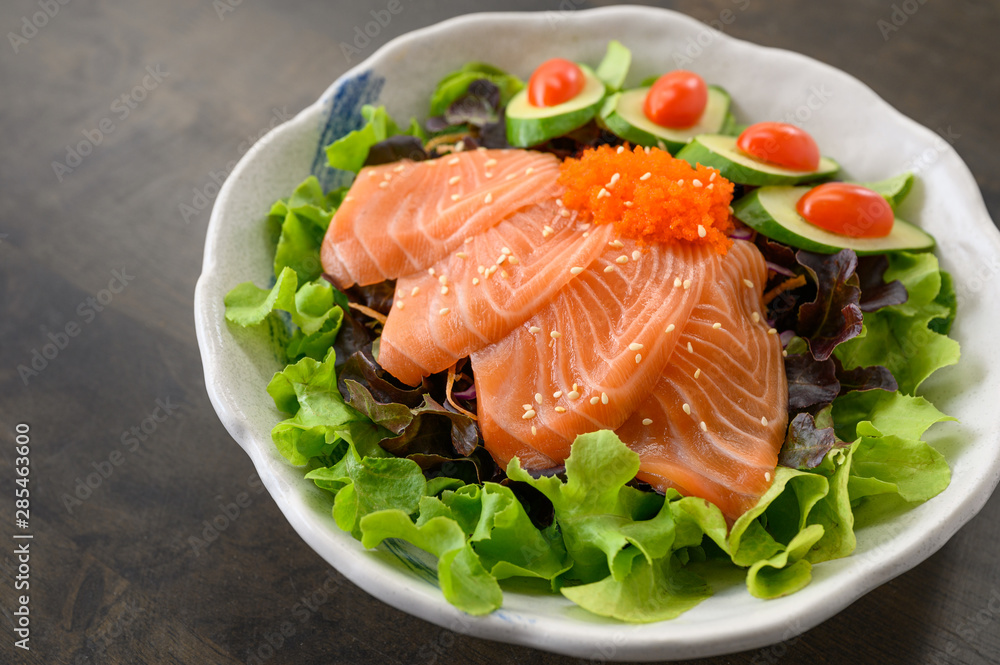 Raw Salmon sashimi with vegetable in ceramic bowl