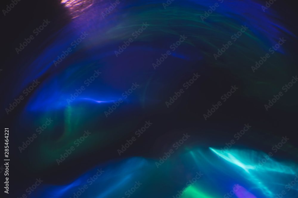 Blur neon multicolor glow. Lens flare effect. Underwater light rays. Dark abstract background.