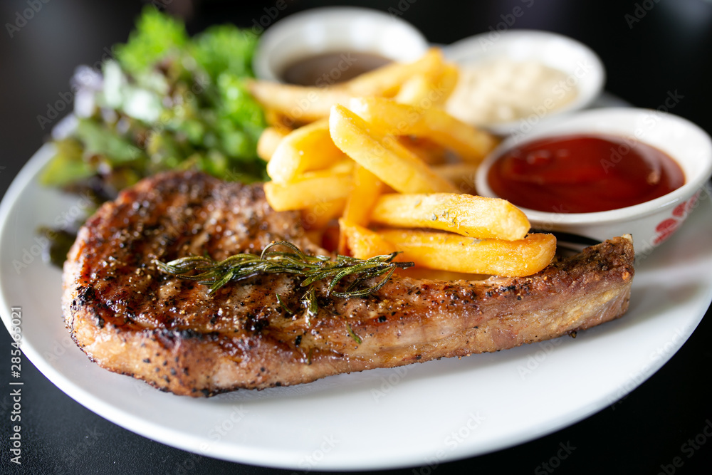 Grilled meat, Porkchops steak with pepper sauce and salad. Grilled meat, Porkchops steak with pepper sauce and salad.