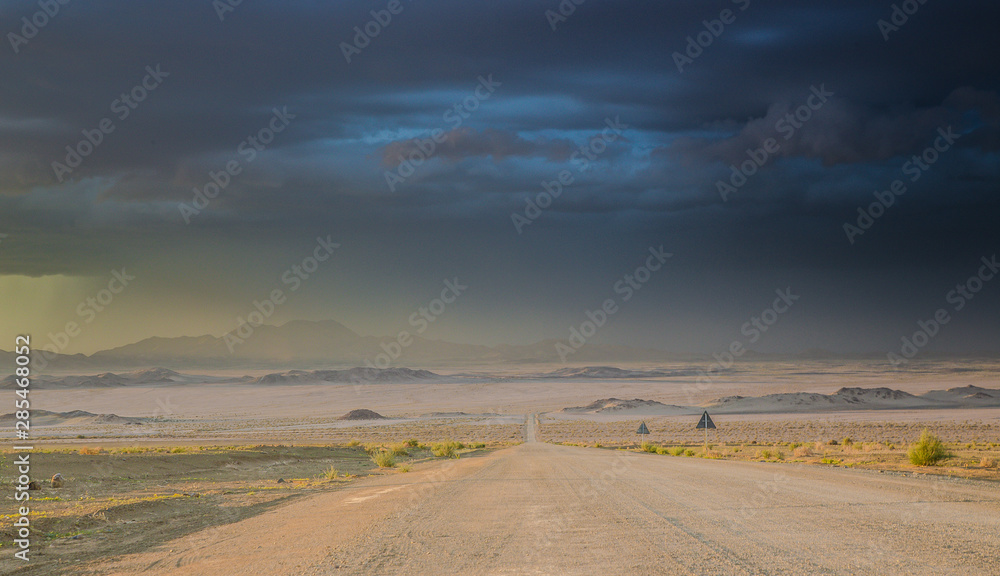 Road in the desert under dark stormy sky Road in the desert under dark stormy sky