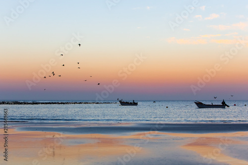 Sunset over fishing boats on the sea