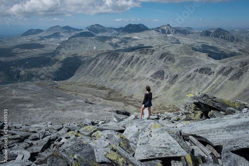 Woman standing on rocky top of Storronden, Rondane National Park, Norway