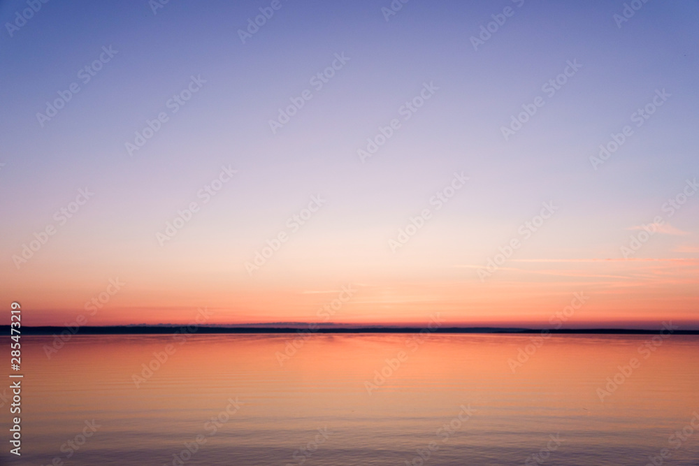 Soft dawn over the sea surface before the sun appears over the horizon on the White sea