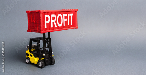 A yellow forklift lifts a red container labeled Profit. The concept of raising profits and income from successful investments and profitable business. Optimization and increase sales. Advertising photo