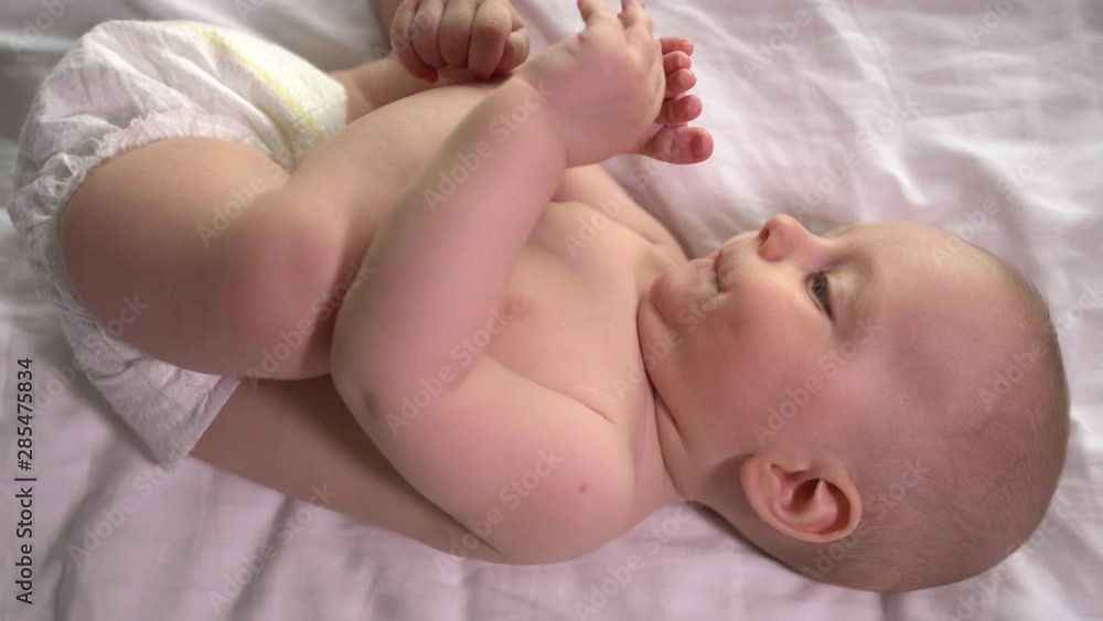 Little baby boy playing with his legs. Bite and suck his foot toes. 4K. Little baby boy playing with his legs. Bite and suck his foot toes. 4K.