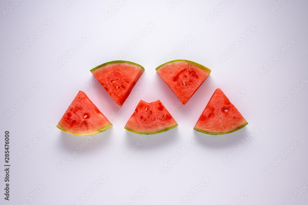 Five slices of water melon against a white background.