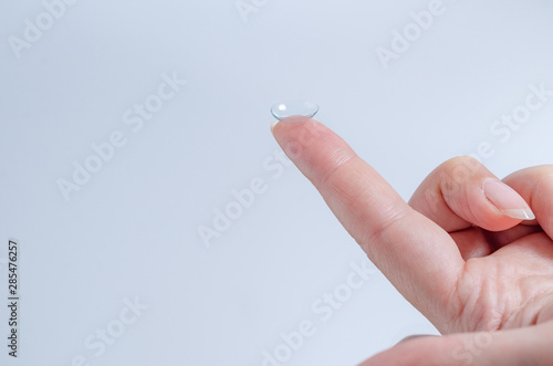 Contact lens close-up on a woman’s fingertip.