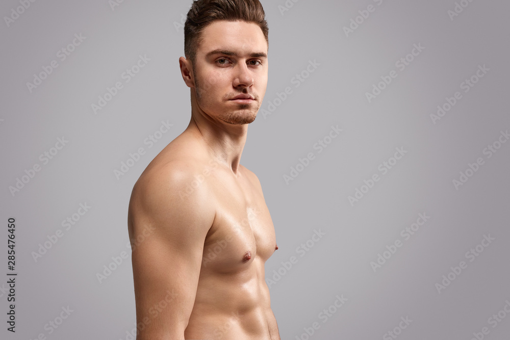 Fototapeta premium Bodybuilder with fit body looking at camera