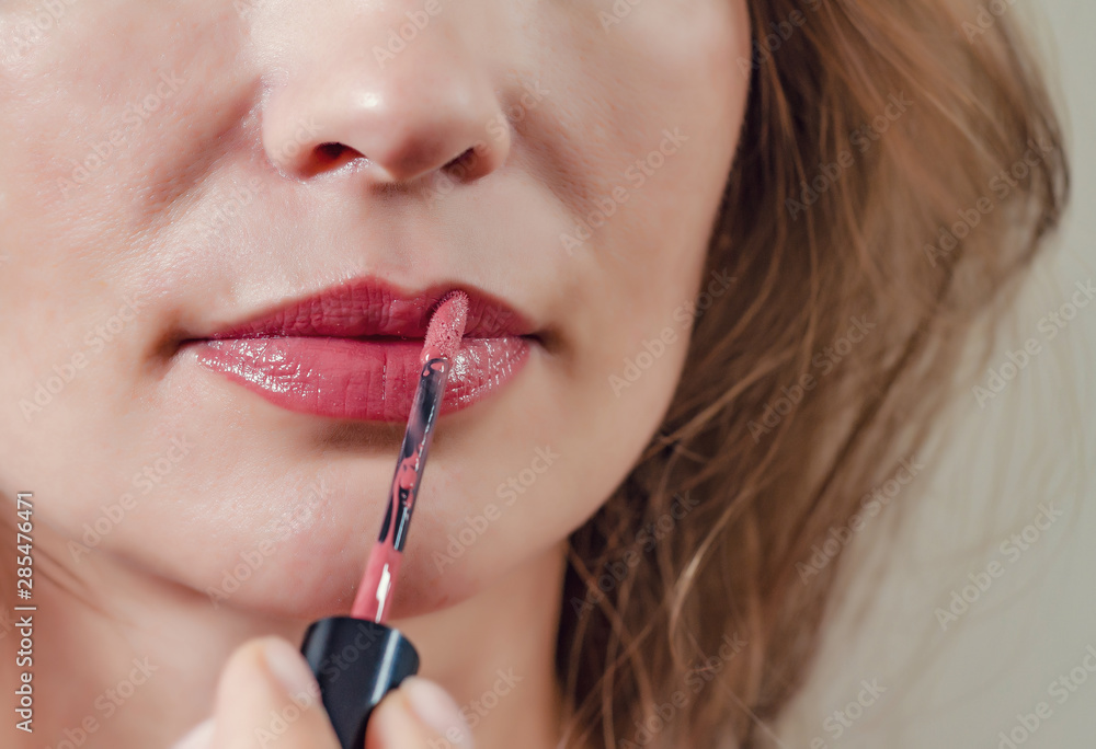 Female lips are painted with red lipstick, closeup. Female lips are painted with red lipstick, closeup.