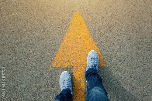 Feet and arrows on road.