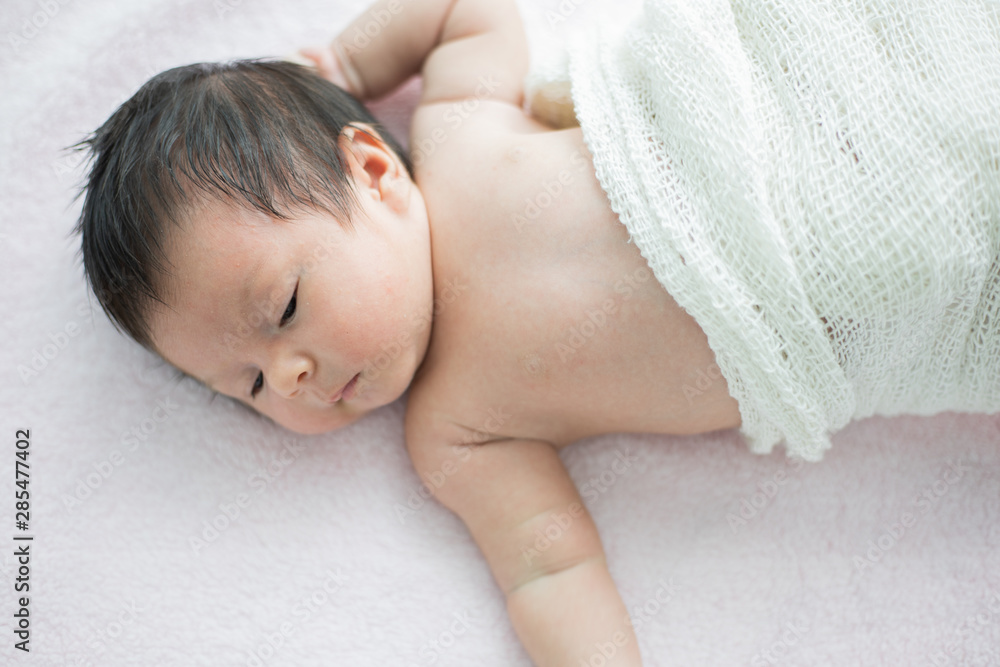 Asian newborn baby sleeping on the bed in living room Asian newborn baby sleeping on the bed in living room