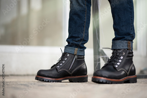 The men model wearing jeans and black boots leather with zipper for man collection.