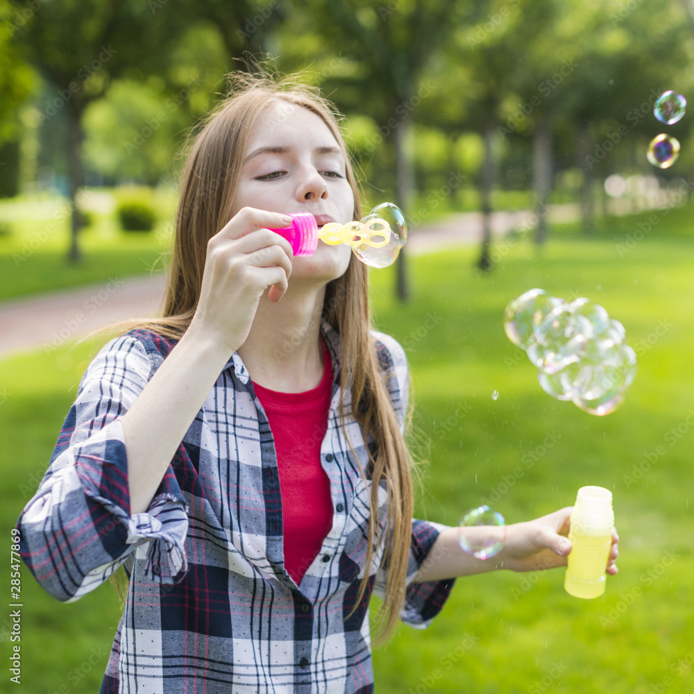 Cute girl making soap bubbles
