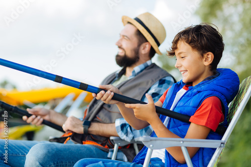 Son feeling excited while fishing for the first time with daddy