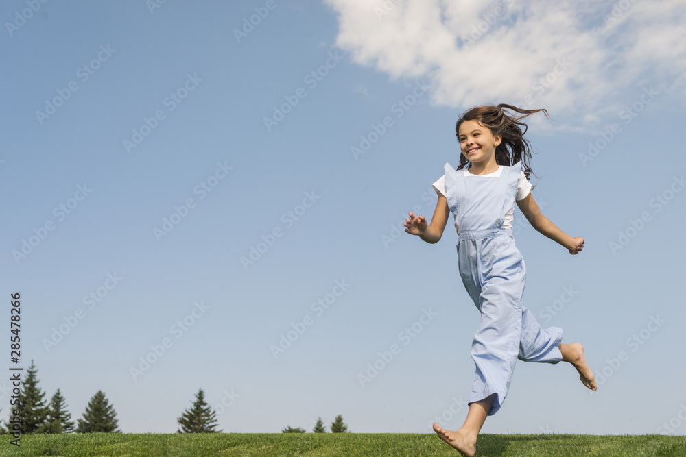 Long shot girl running barefoot on grass Long shot girl running barefoot on grass