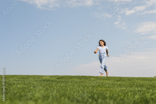 Girl running barefoot on grass