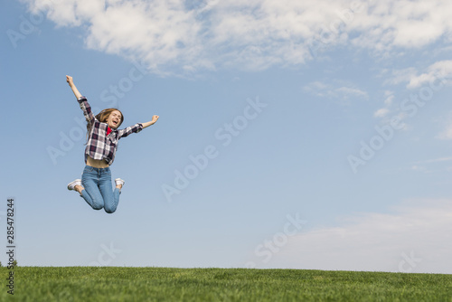 Front view girl jumping as high as she can