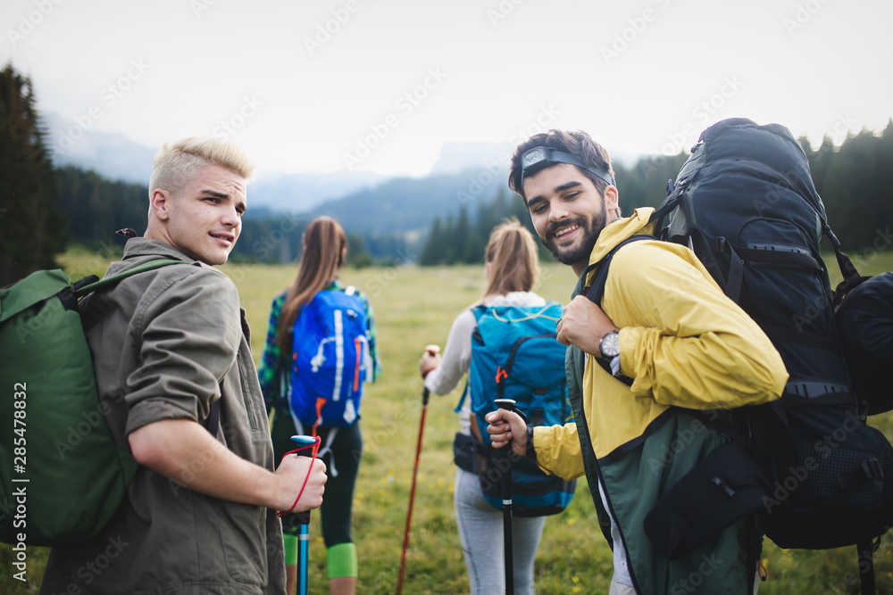 Group of hikers walking on a mountain and smiling