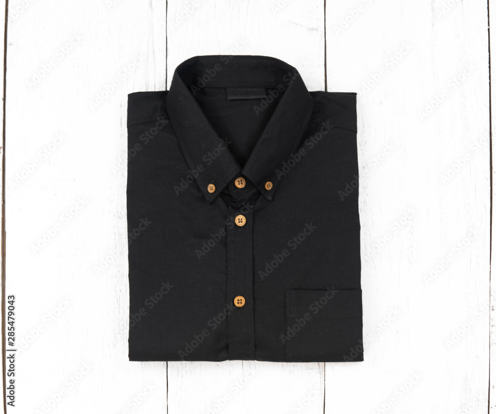 Mens clothing. Black shirt isolate on white wooden background, Top view Mens clothing. Black shirt isolate on white wooden background, Top view