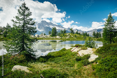 Górski krajobraz z jeziorem i zielonymi drzewami wokół. Poczucie wolności. Park Narodowy Gran Paradiso, jezioro Bellagarda, Ceresole Reale, Piemont, Włochy