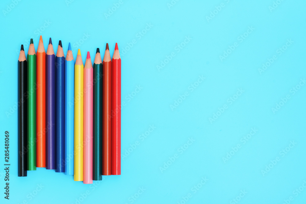 Fototapeta premium Colored pencils. A set colored pencils isolated on a blue background.