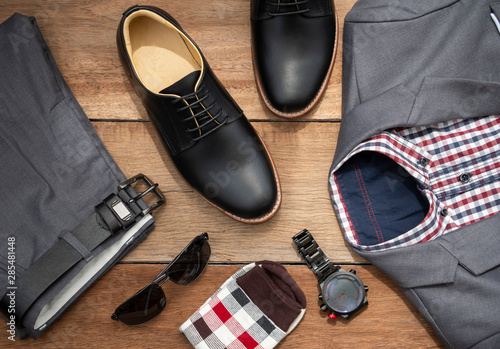Men fashion casual clothing set and accessories isolated on wooden background include black derby shoes, gray suit, pants, belt, sunglass, sock and scottis office shirt. Flat lay, top view