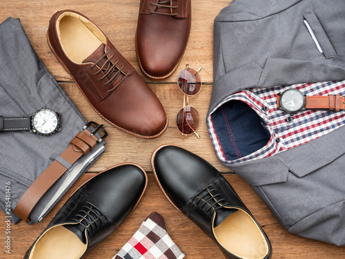 Men fashion casual clothing set and accessories isolated on wooden background include derby shoes, gray suit, pants, belt, sunglass, sock and scottis office shirt. Flat lay, top view