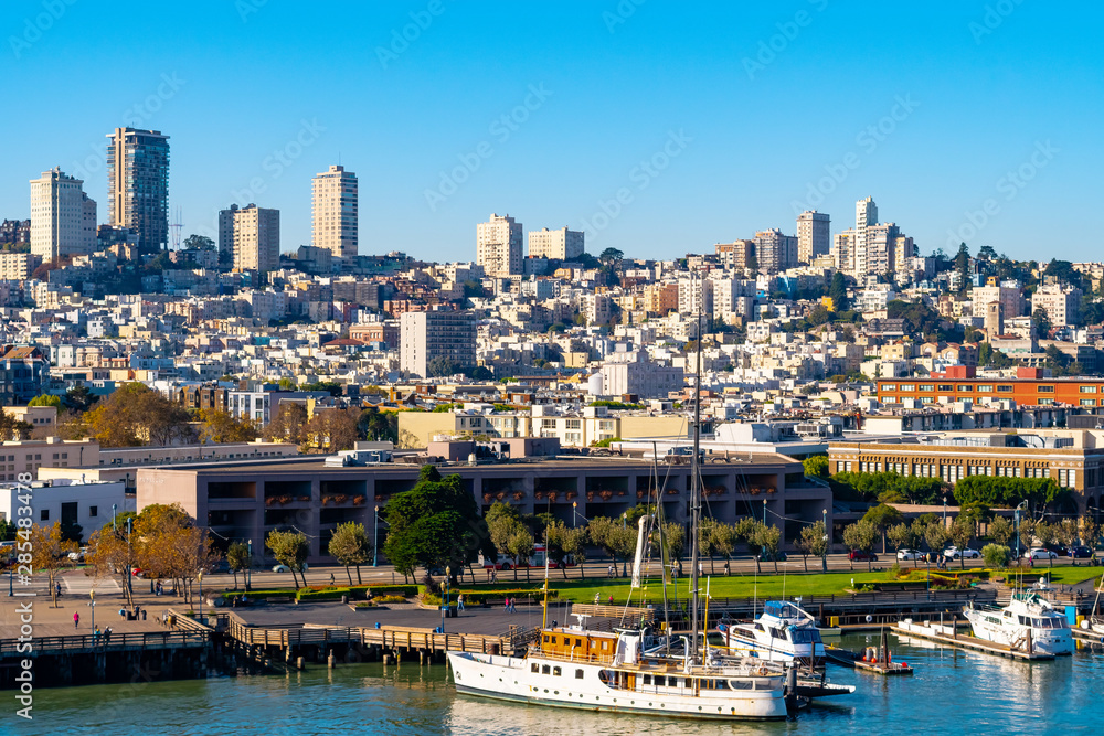 Obraz premium San Francisco, California cityscape and skyline. Yachts and boats berthed by the coastal waterfront, high rise skyscraper buildings and other modern architecture fill the dense west coast city.