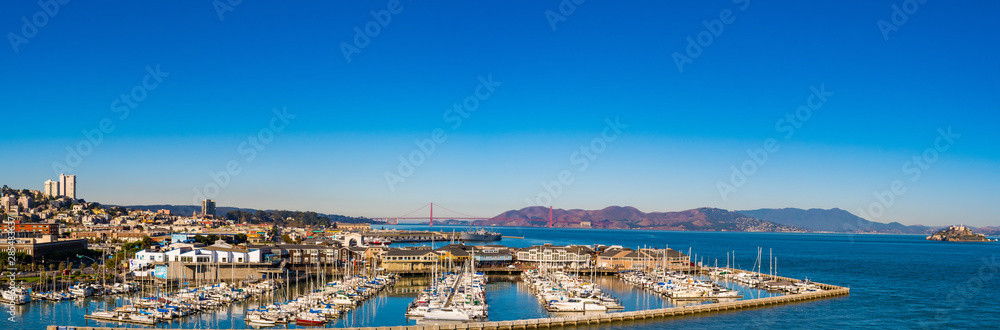 Panorama cityscape skyline view with Golden Gate Bridge, Alcatraz and buildings. Yachts and boats berthed by the waterfront pier in the west coast city.
