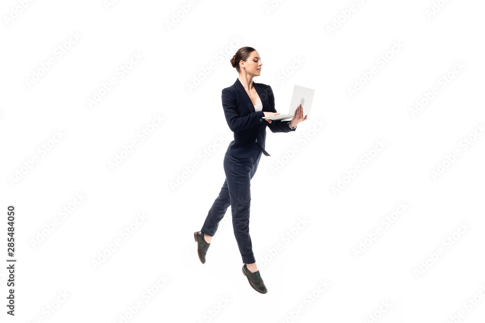 beautiful graceful businesswoman in black formal wear dancing while using laptop isolated on white beautiful graceful businesswoman in black formal wear dancing while using laptop isolated on white
