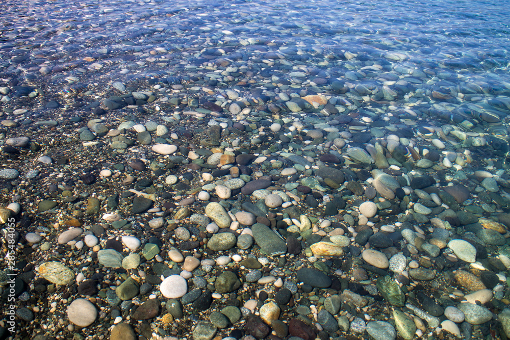 Sea stones in sea water. Pebbles under water. The view from the top. Nautical background. Clean sea water. Transparent sea. Sea stones in sea water. Pebbles under water. The view from the top. Nautical background. Clean sea water. Transparent sea.
