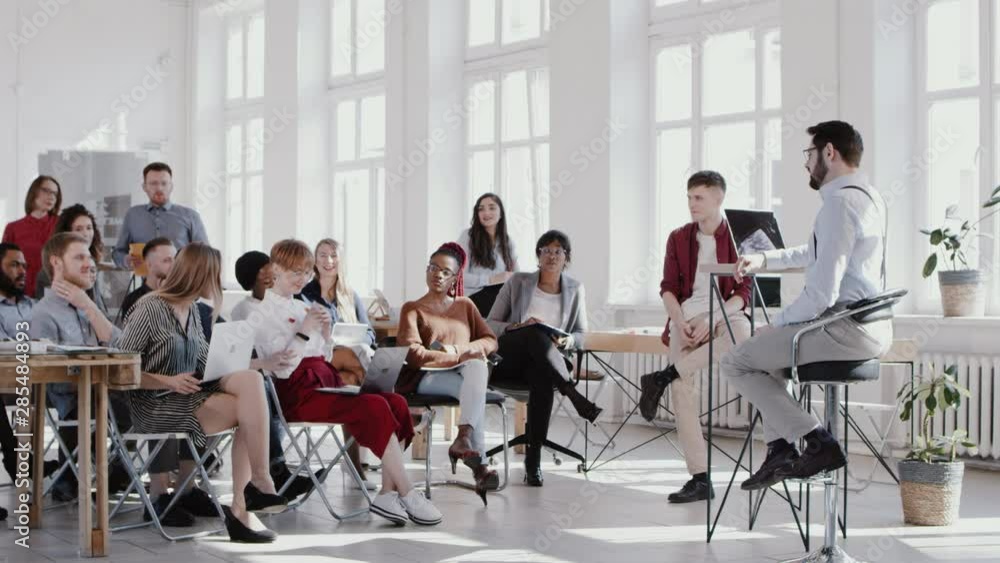 RED EPIC Young professional businessman coach leading modern light office seminar event for multiethnic team slow motion RED EPIC Young professional businessman coach leading modern light office seminar event for multiethnic team slow motion