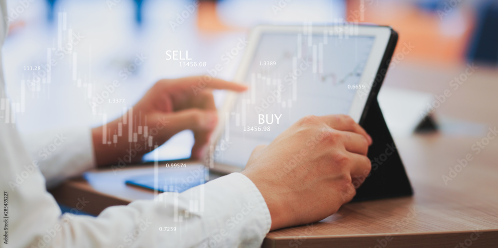 close up expert investor of stock trader hand touching on screen tablet and monitoring trading board for forecasting about buying or selling currency exchange rate , business with technology concept close up expert investor of stock trader hand touching on screen tablet and monitoring trading board for forecasting about buying or selling currency exchange rate , business with technology concept